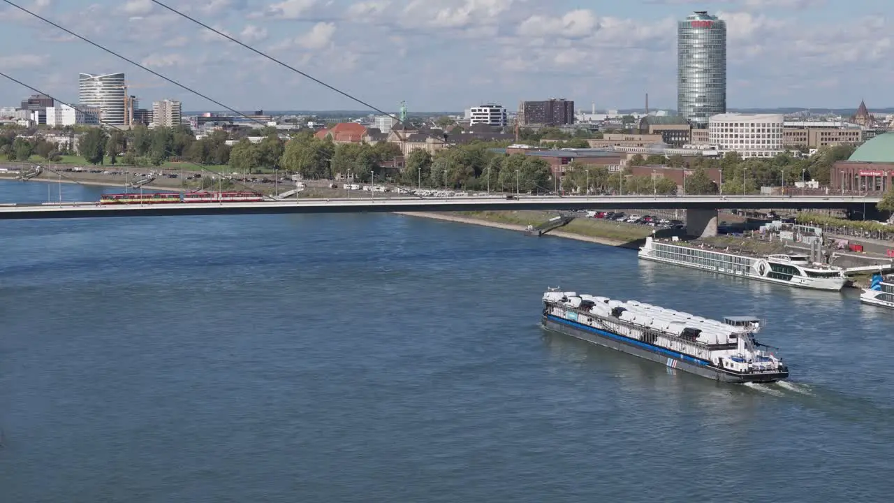 Aerial of a cargo ship passing beneath a bridge on the Rhine River