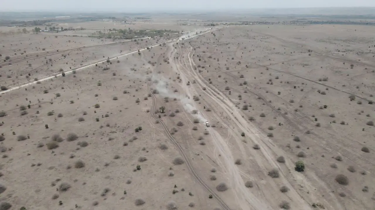 Aerial view of a truck driving Through The Dusty Desert