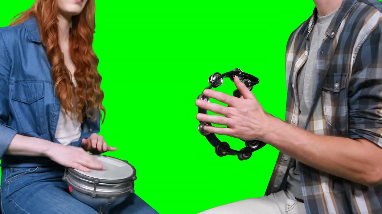 Mid section of musicians playing tambourine and drum