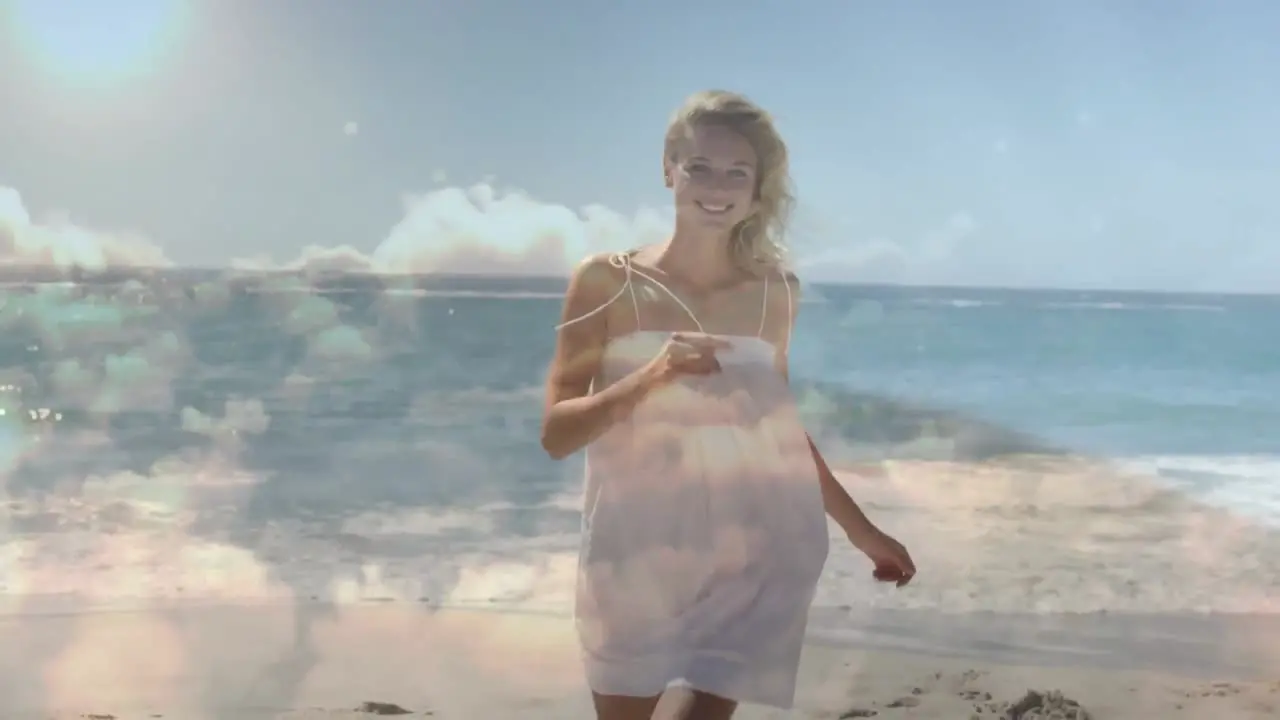 Animation of clouds over smiling caucasian woman walking on beach