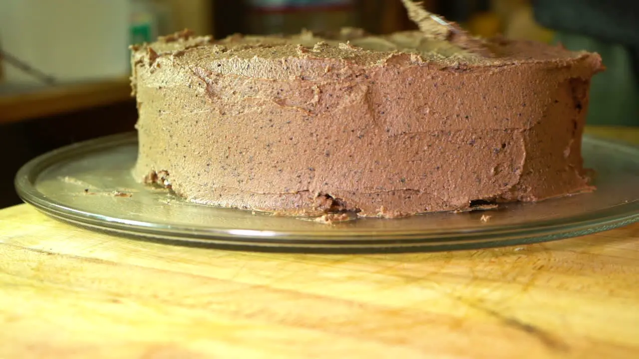 Frosting a delicious homemade gluten free two layer chocolate cake Slow motion