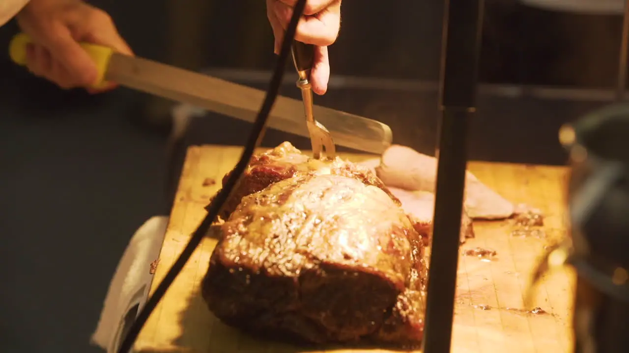 Chef slicing roast beef on a cutting board