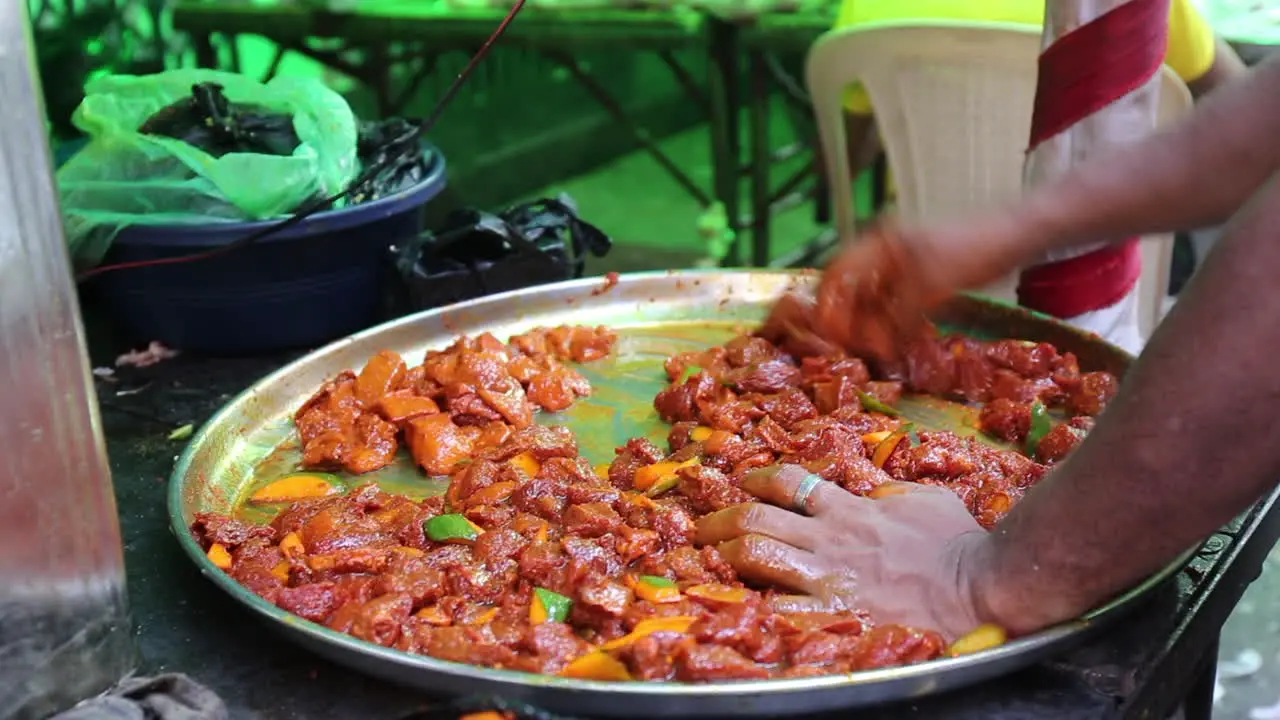 a food vendor mixing spices in meat