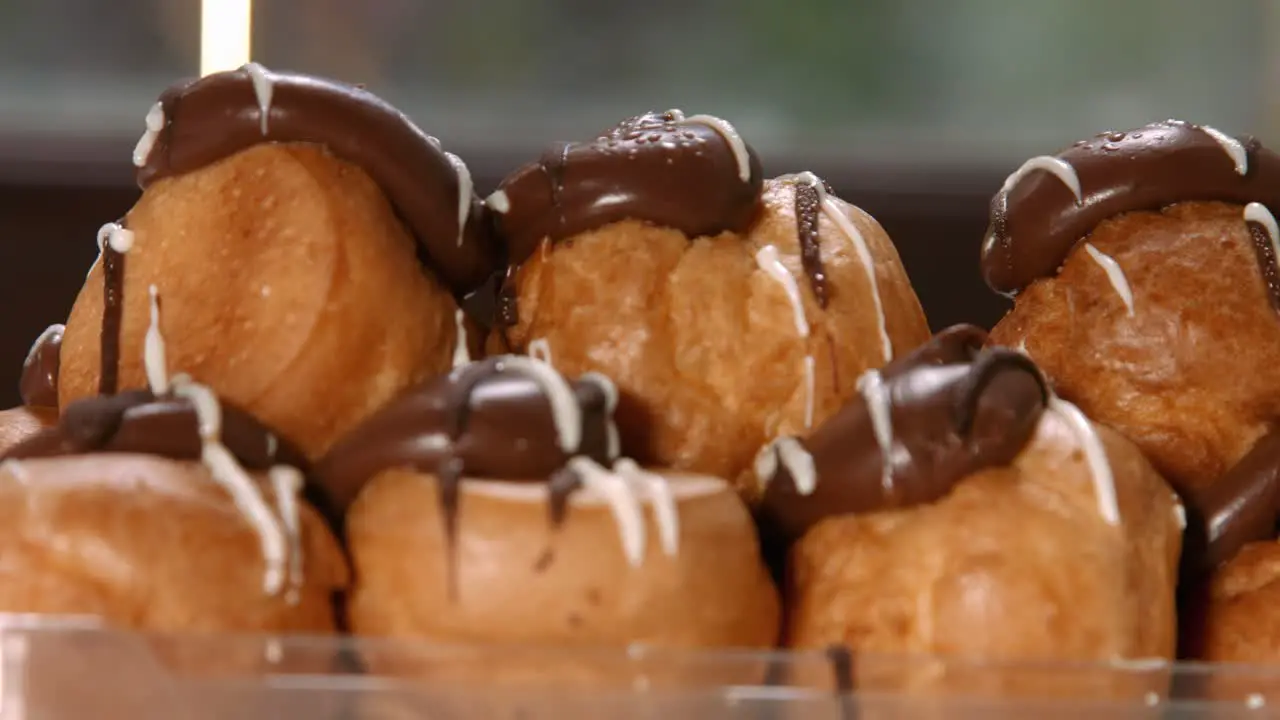 Slow Pan of Profiteroles French Choux Pastry Whipped Cream Filling and Chocolate Top