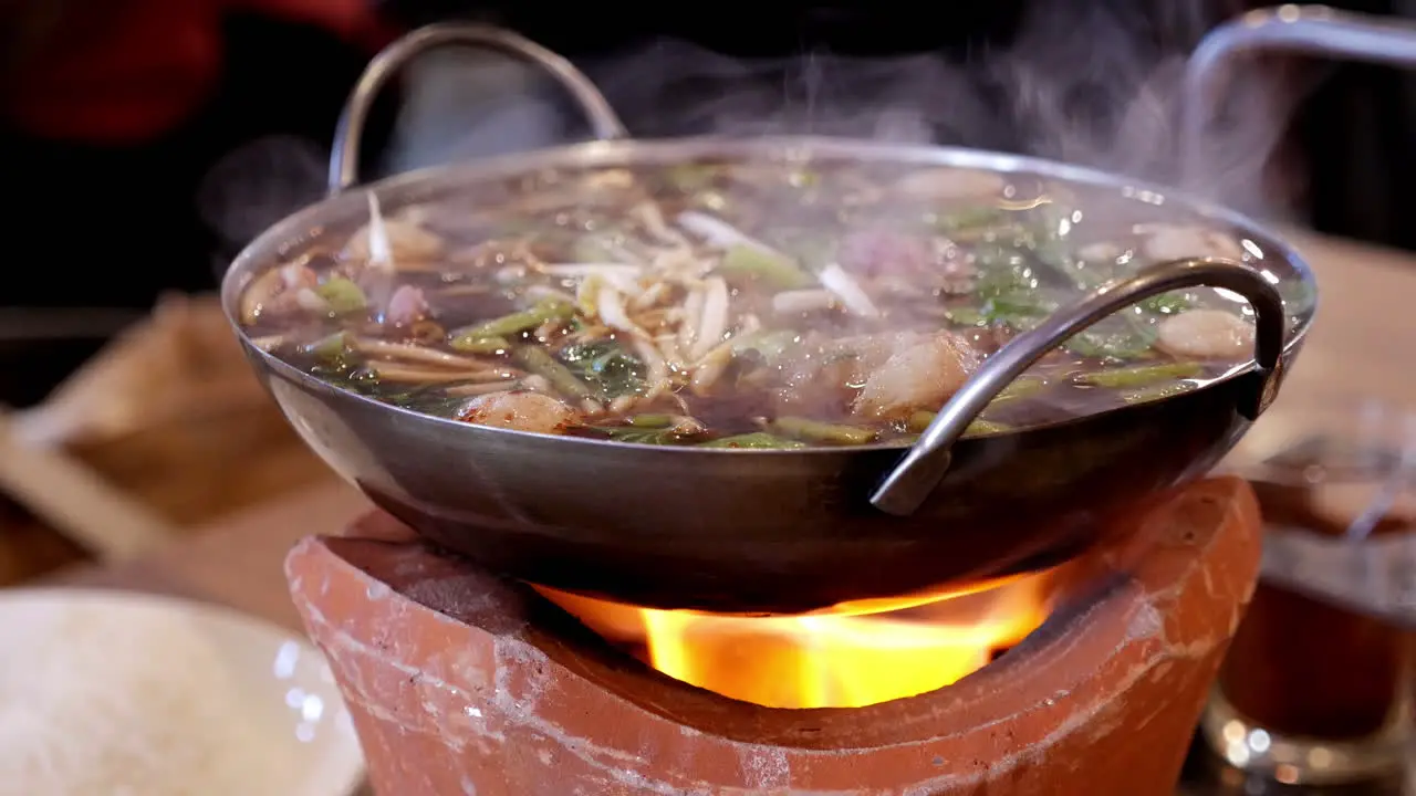 Cooking spicy oxtail noodle soup on a firewood stove