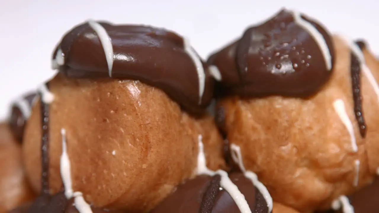 Close Up of Delicious French Profiteroles with Whipped Cream Filling and Chocolate Top