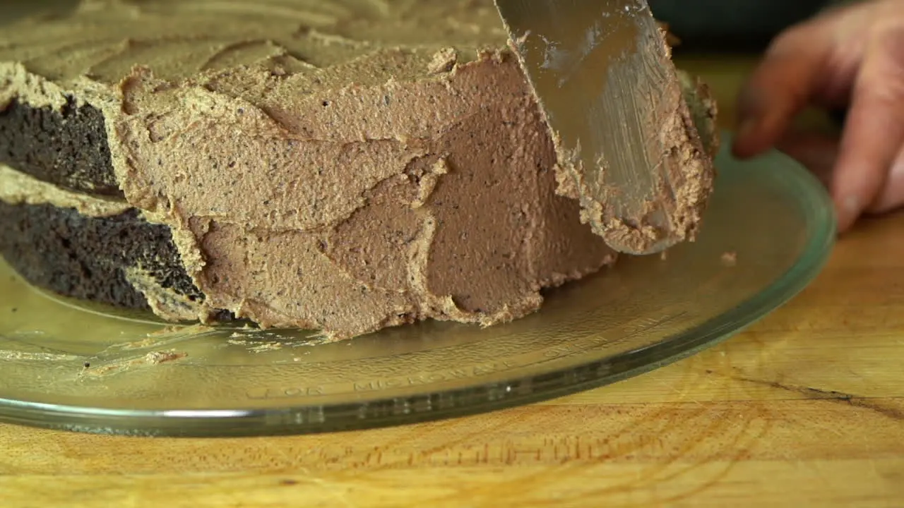 Slow motion clip of frosting a delicious two layer chocolate cake