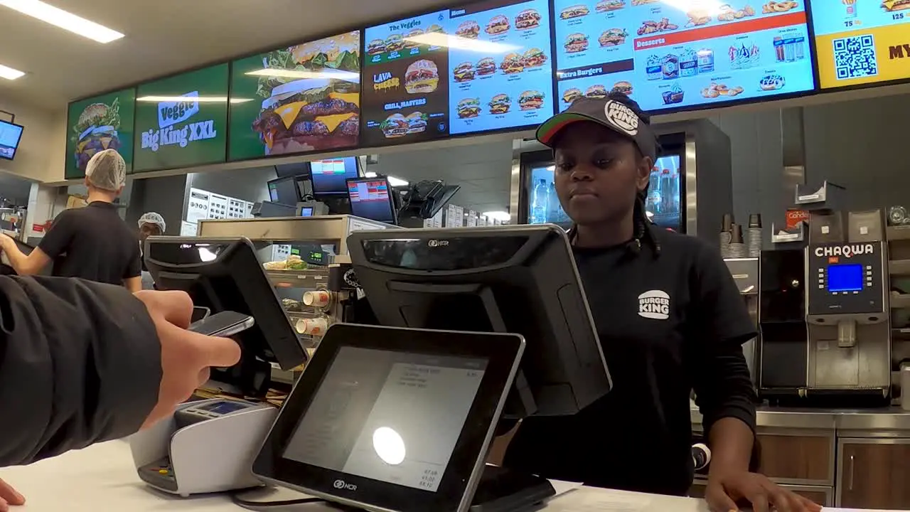 Burger King's employee making food order from customer on touch screen of computer inside the restaurant Brussels Belgium