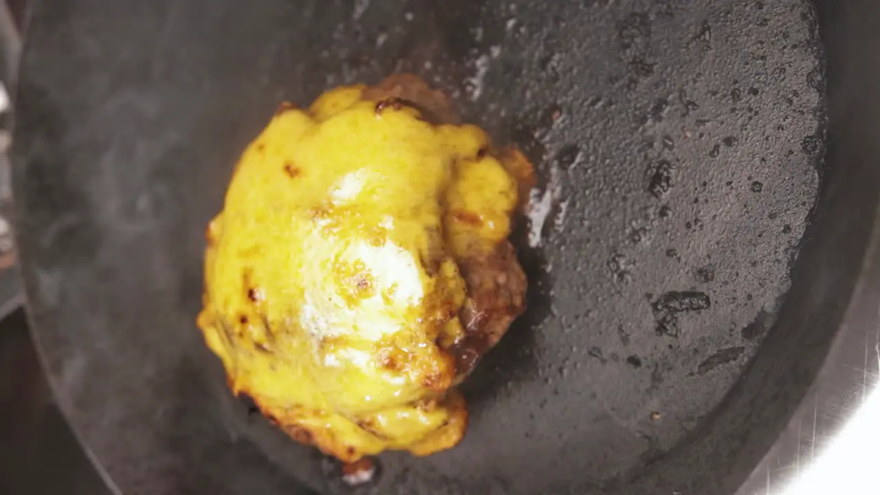 From Close up to Medium Shot of Cheesy Melted Crust on Meat Patty while on Hot Pan Portrait