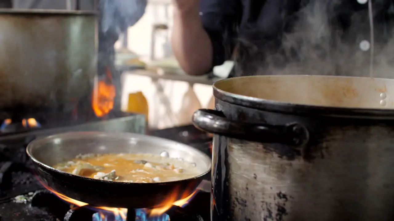 Chef preparing seafood risotto in restaurant close-up Mediterranean