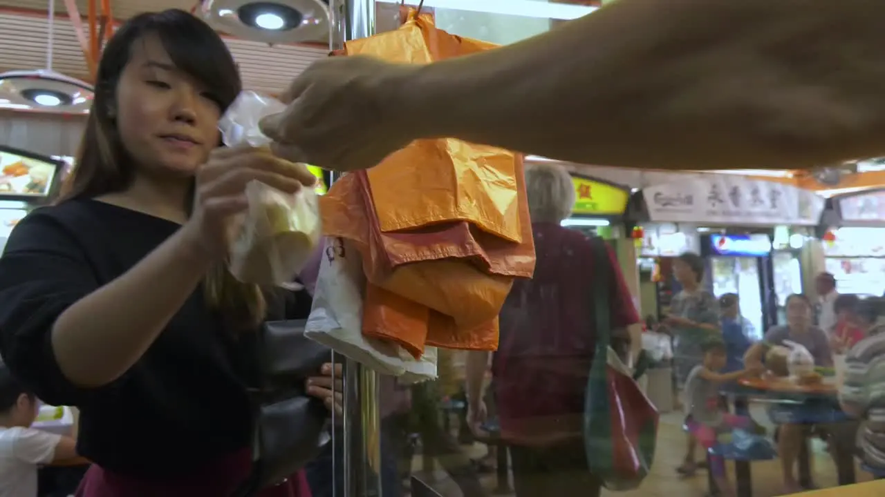 Woman client being served a delicacy in Food Market Singapore Medium detail tracking shot