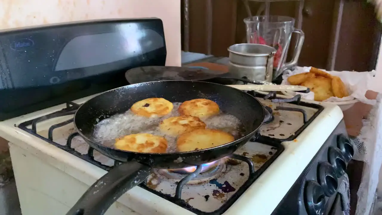 Woman cooking potato cakes in oil mexican food