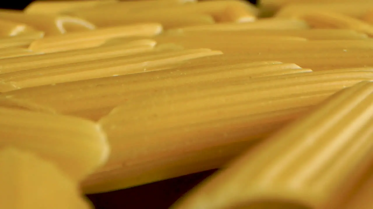 Dolly Shot Of Italian Pasta Penne on a black mirror table