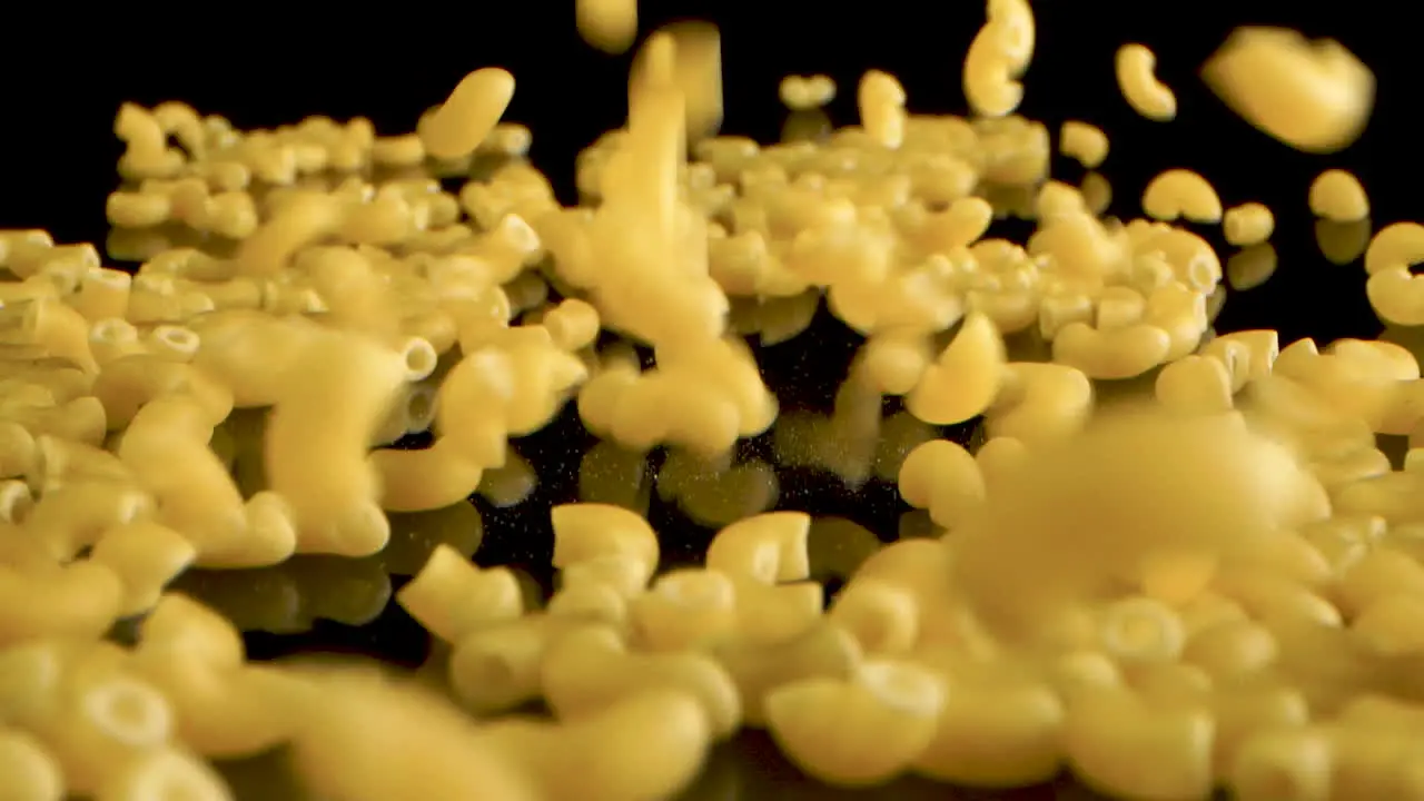 French pasta macaroni coquillettes Falling on black table Slow Motion