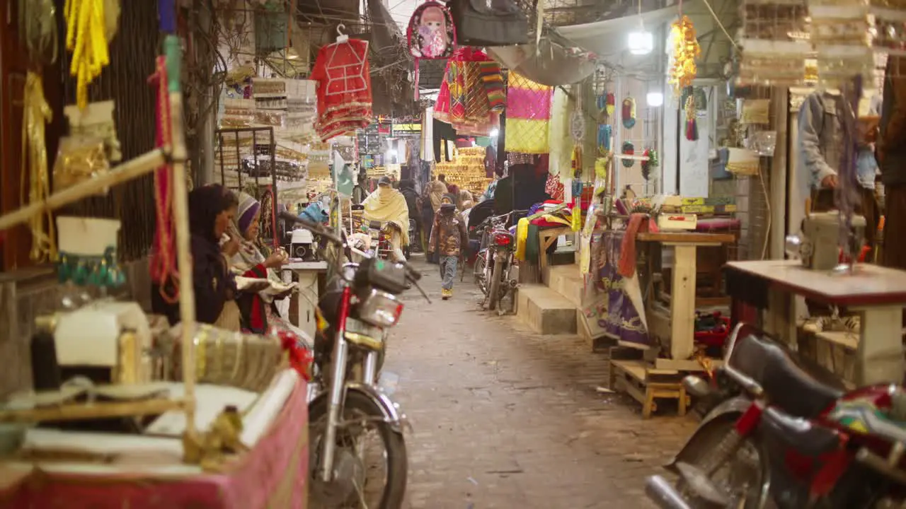 People walking in the streets during a market in Pakistan while a scooter approach