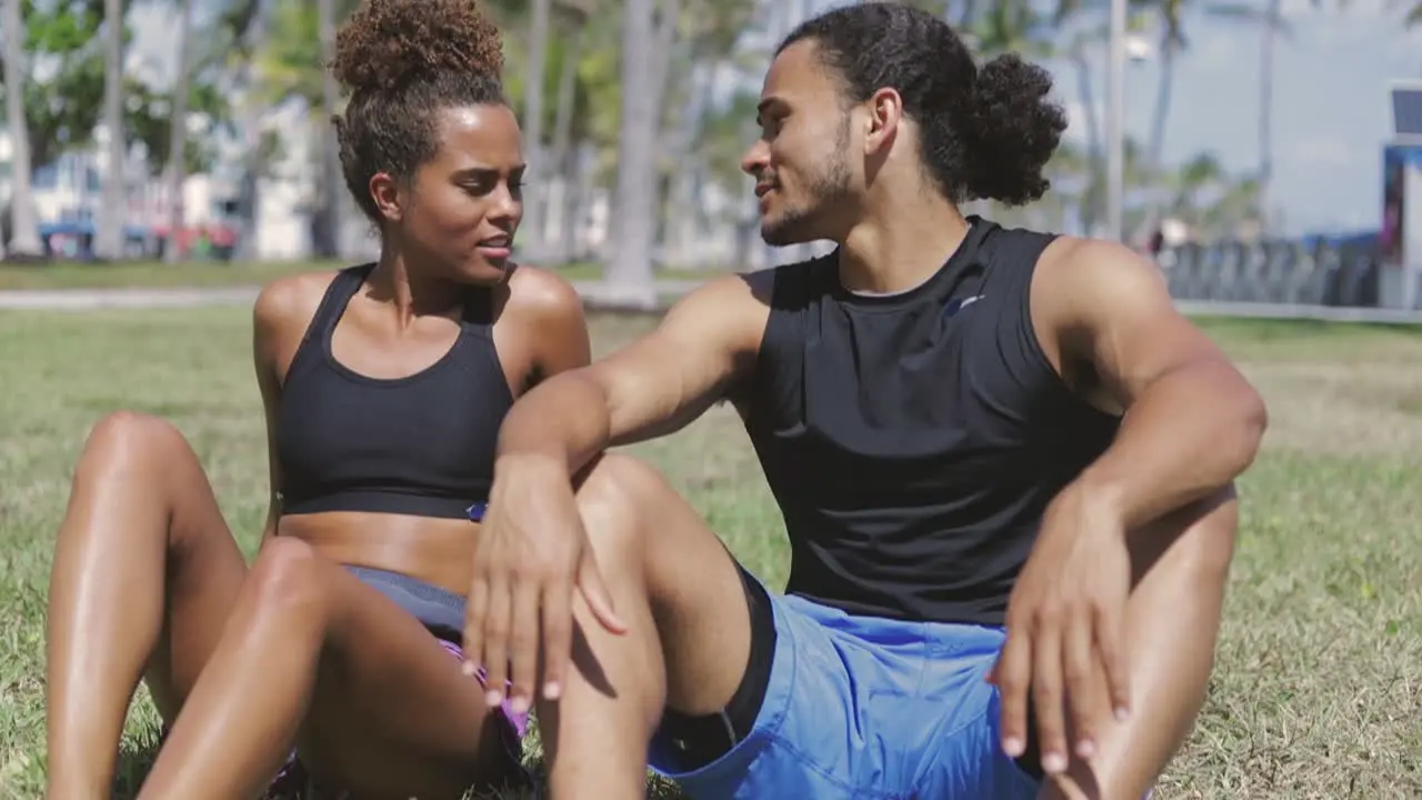 Fit couple resting on green grass