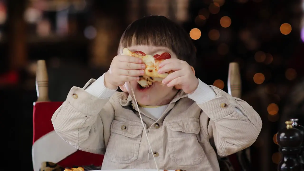 Little hungry boy eating tasty italian pizza