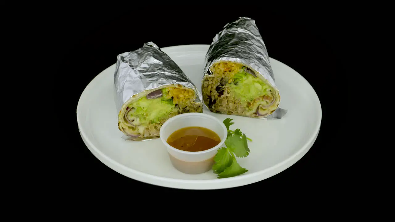 Foil-wrapped burrito on a turntable with mild sauce