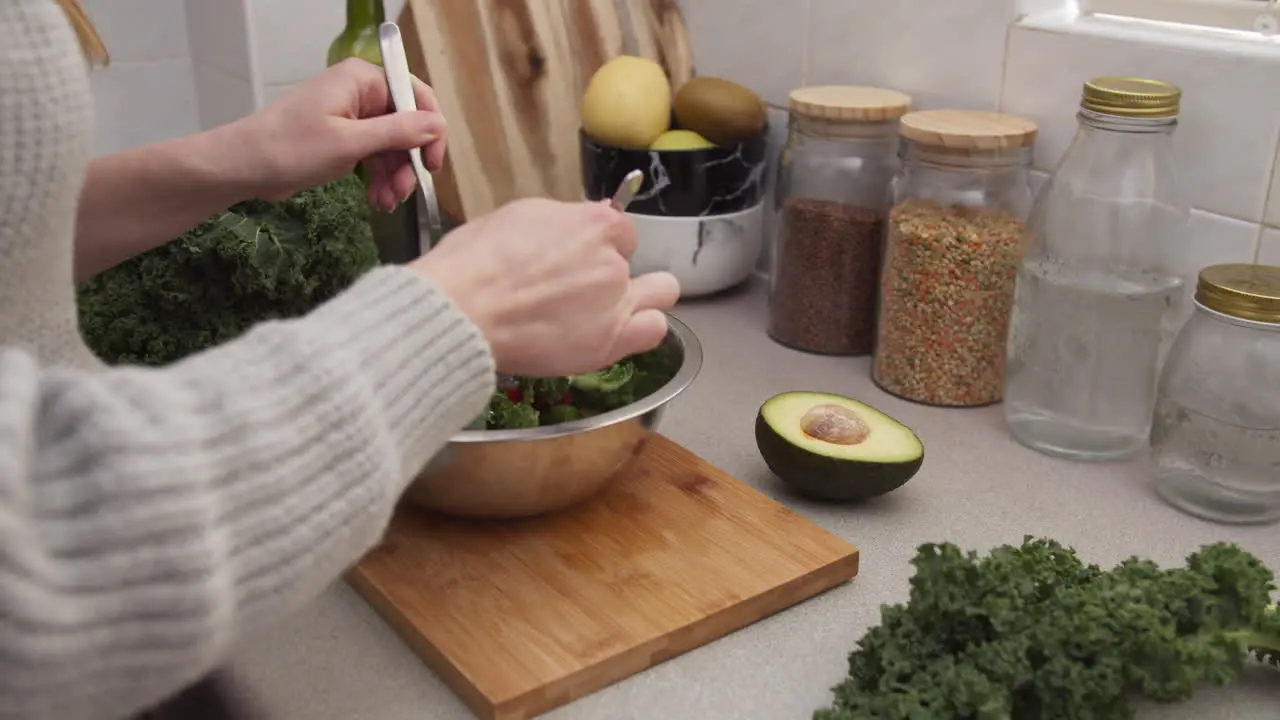 Female hands mixing salad in a bowl Vegetarian salad dish Healthy homemade food