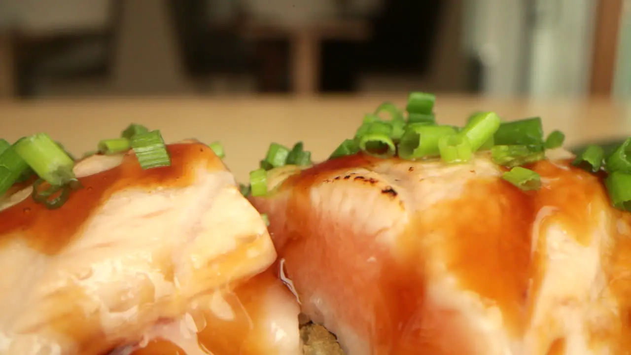 Salmon Sushi Rolls Garnished With Fresh Onion Chives macro slow panning shot