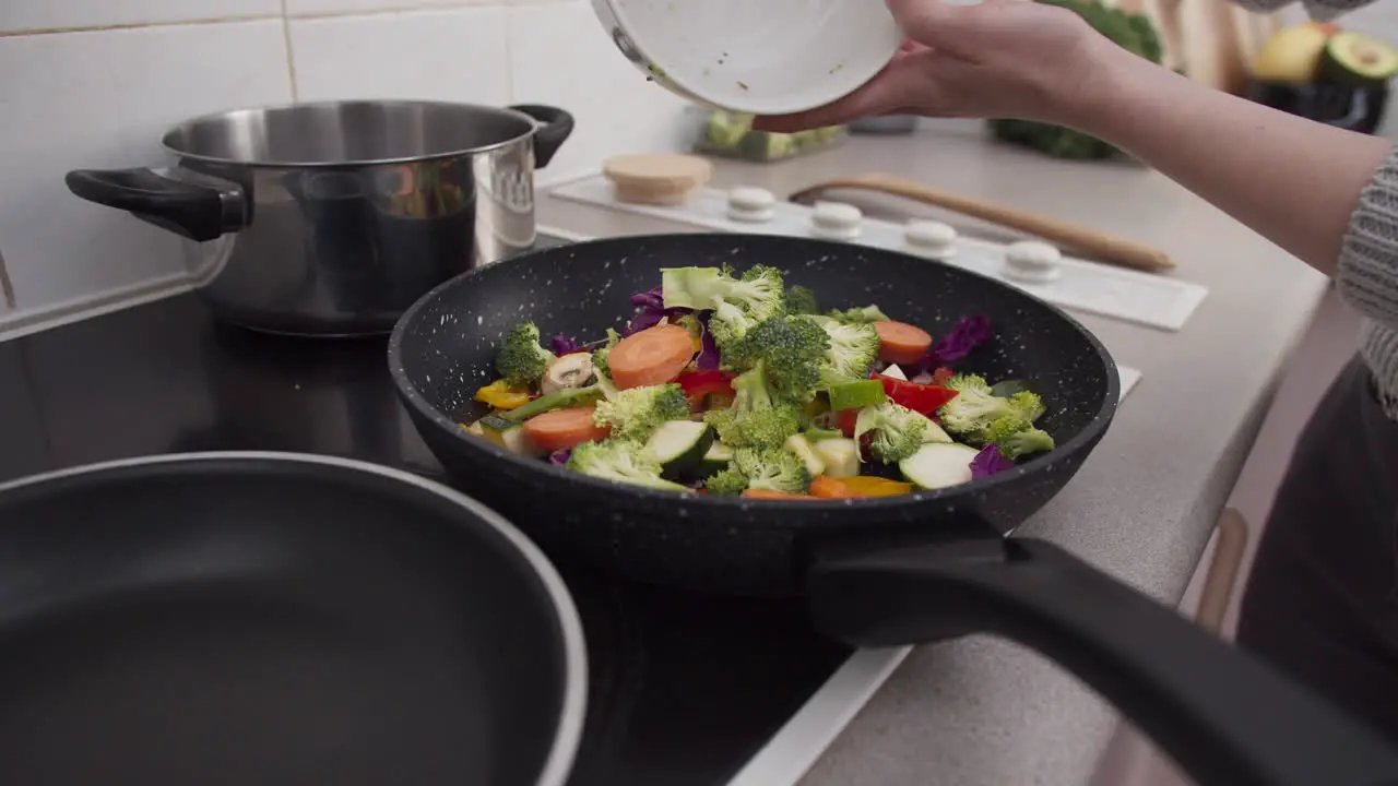 Vegetables falling into the frying pan in slow motion close up shot