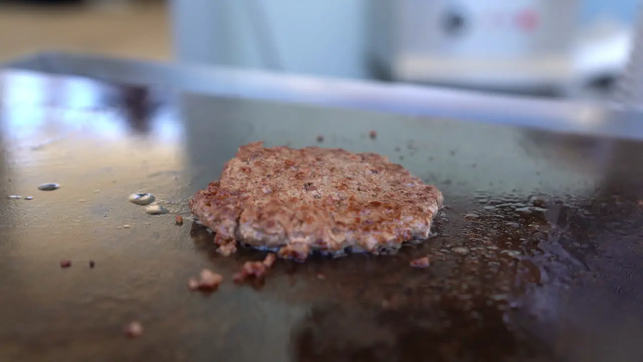 Cooking a piece of burger on the grill close up