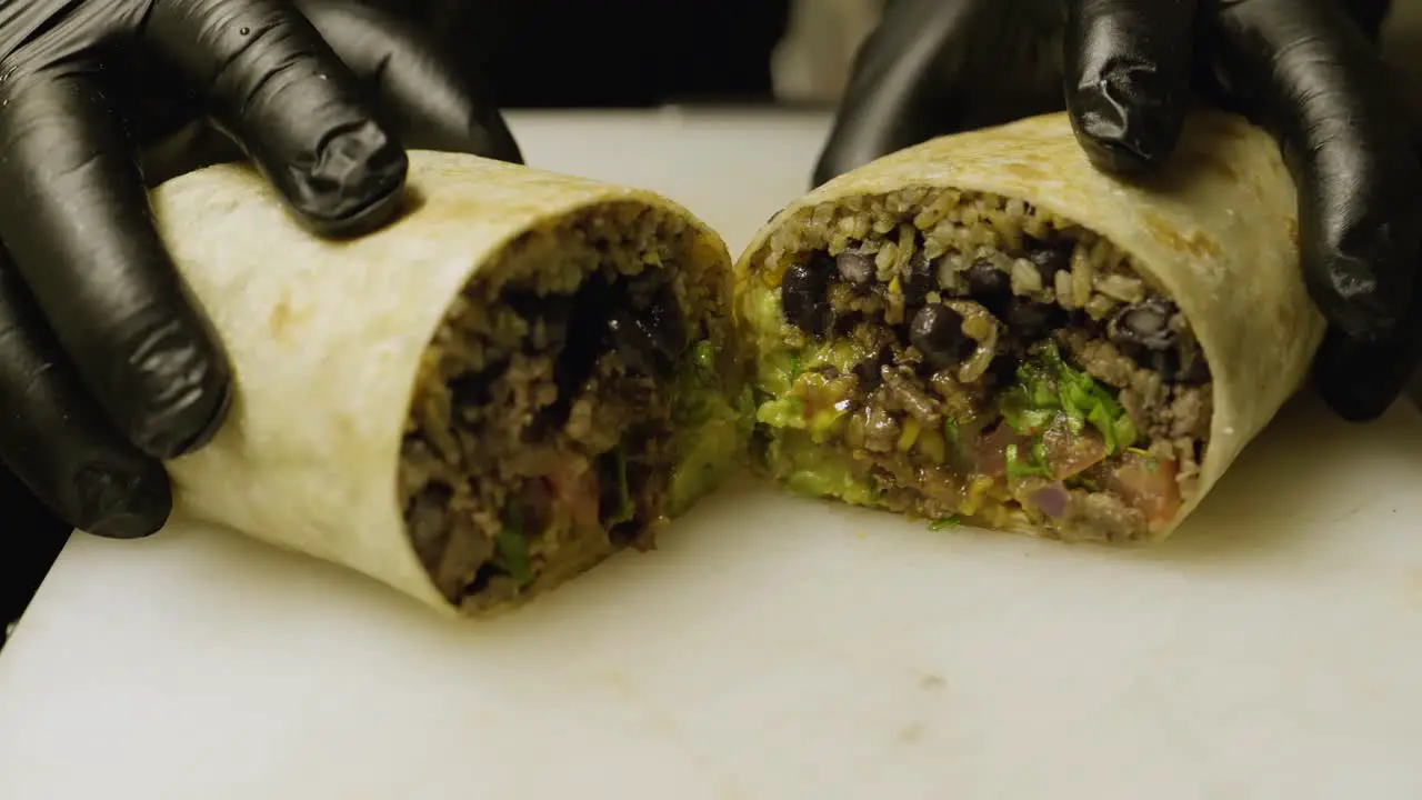 Ched cuts burrito in half and shows it