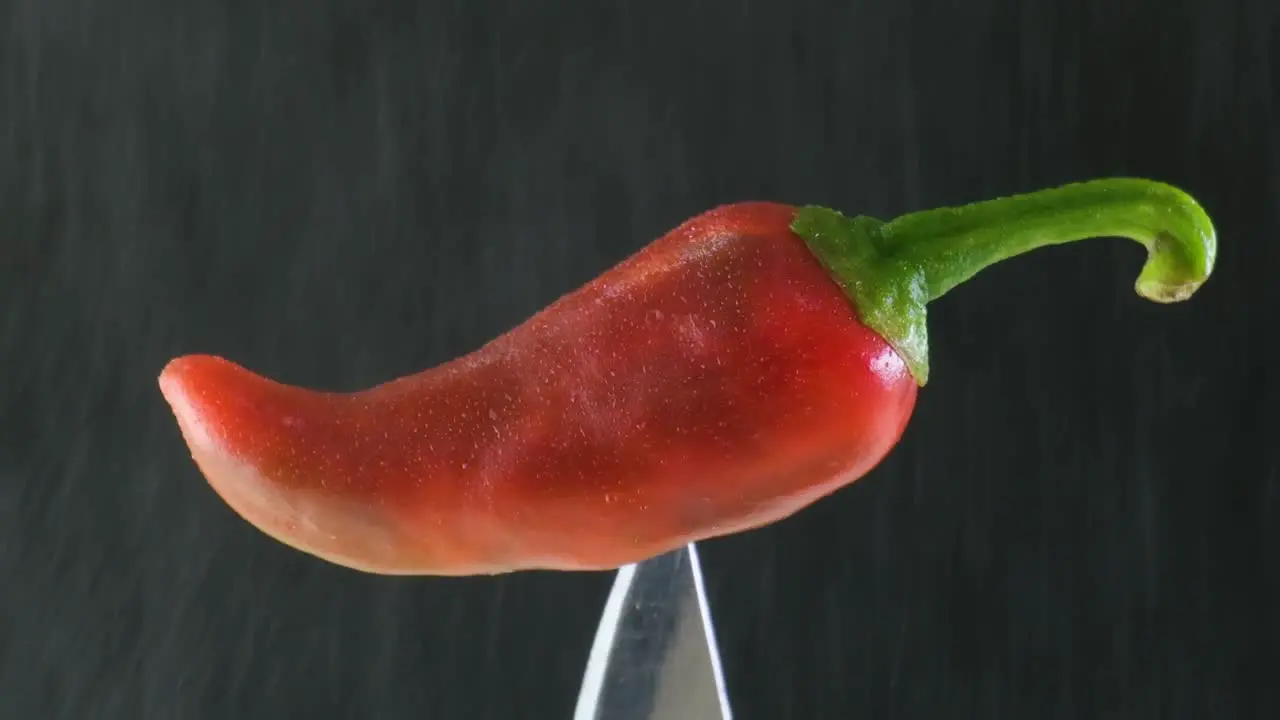 Spicy Food Water Spraying on Burning Red Chili Pepper Stuck on a Knife