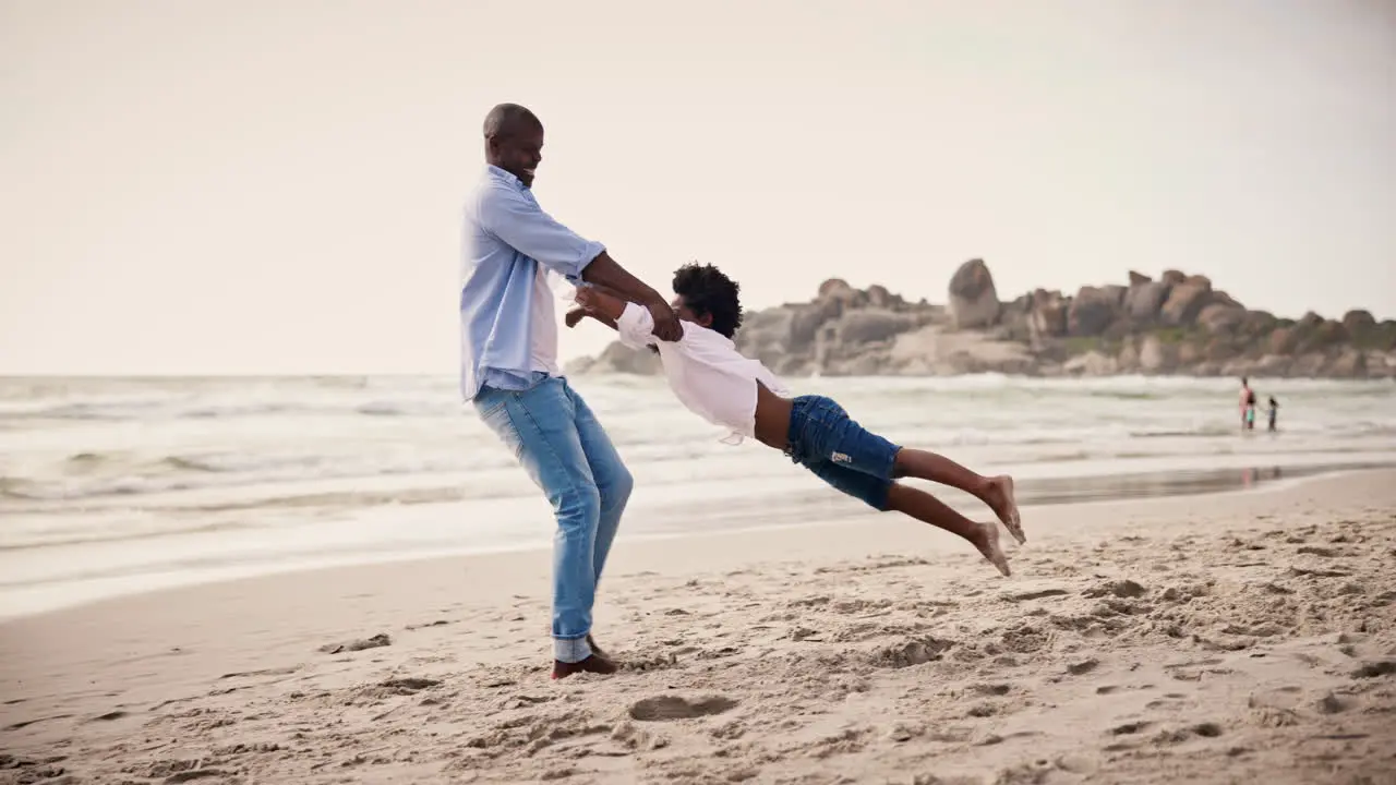 Black family beach and a father spinning his son