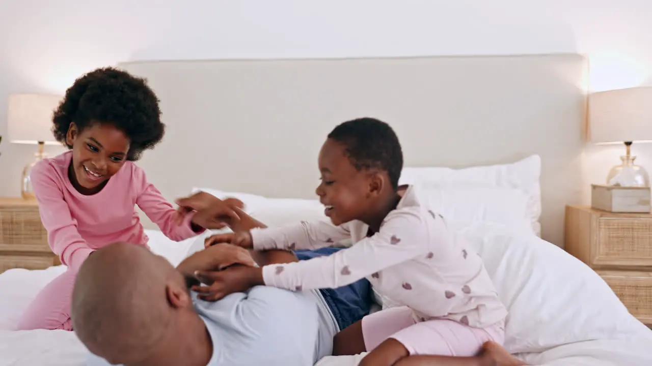 Black family bedroom and children tickling