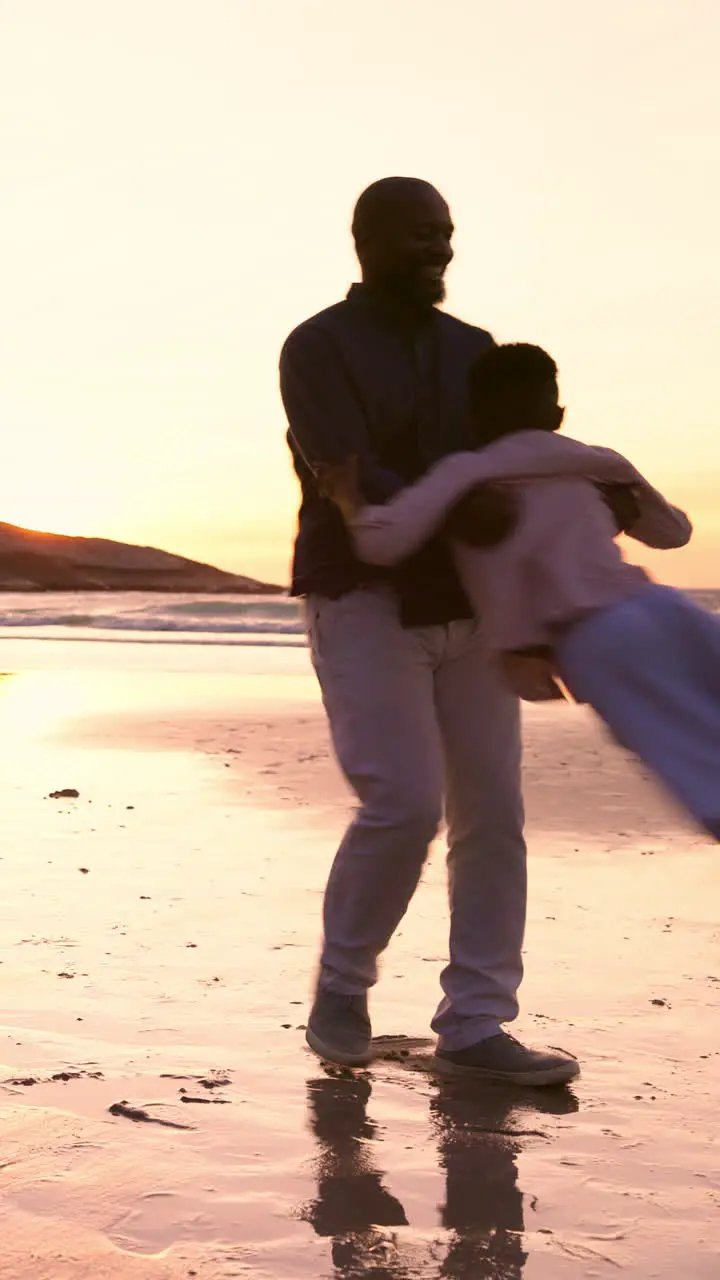 Father child and spinning at beach in sunset