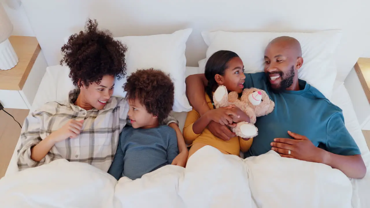 Happy family kids and parents in bed