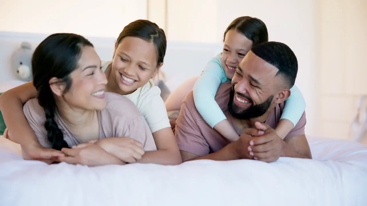 Happy family parents and kids on bed with hug