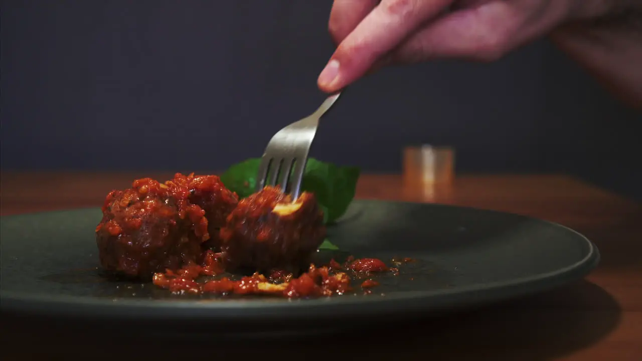 Side View of a Man eating Meatballs in Tomato Sauce well presented dish and fine dining experience