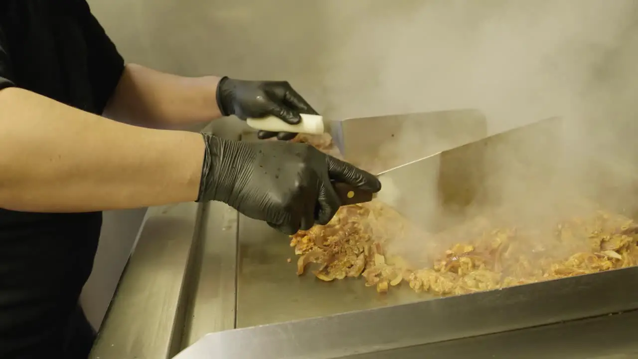 Person cooking meat on grill