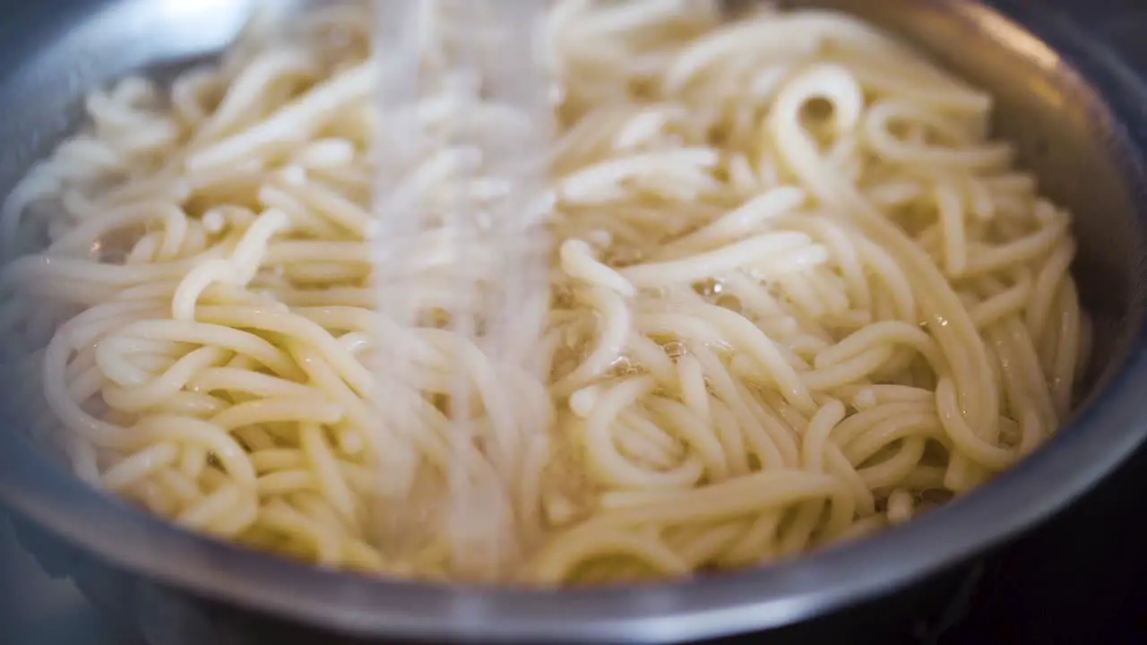 Rinsing a pot of spaghetti in the kitchen sink