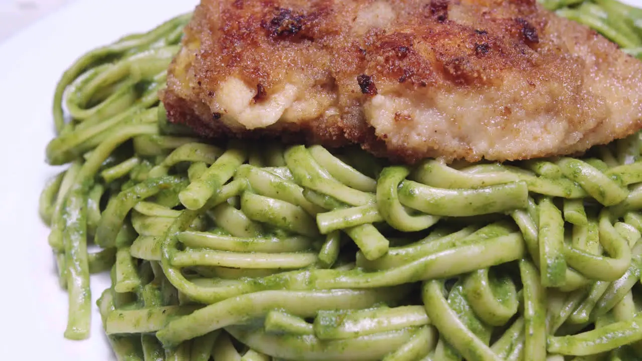 Authentic fried breaded chicken with green spaghetti