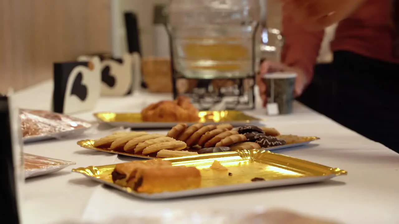 Hands Of Guests Picking Up Baked Cookies From Metal Tray On The Table