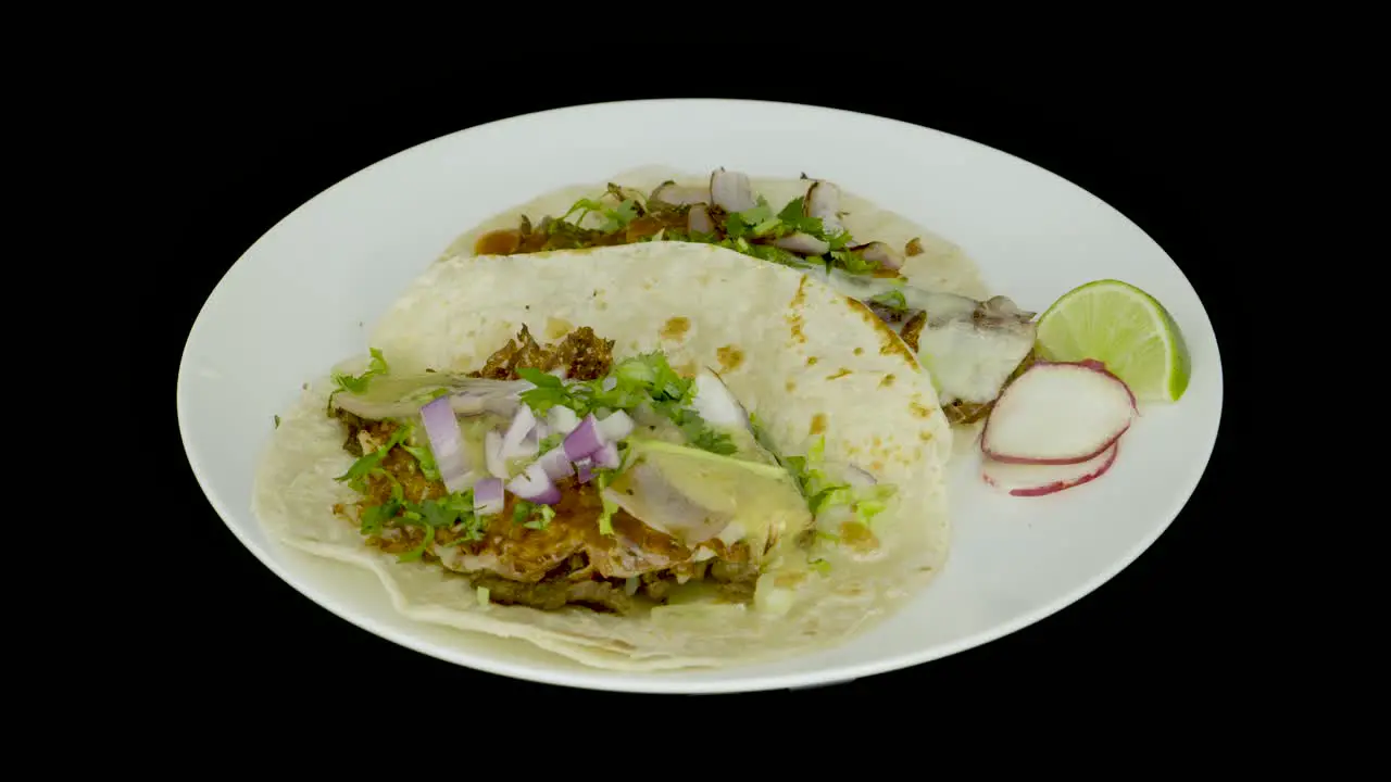 Two tacos with cheese on a turntable