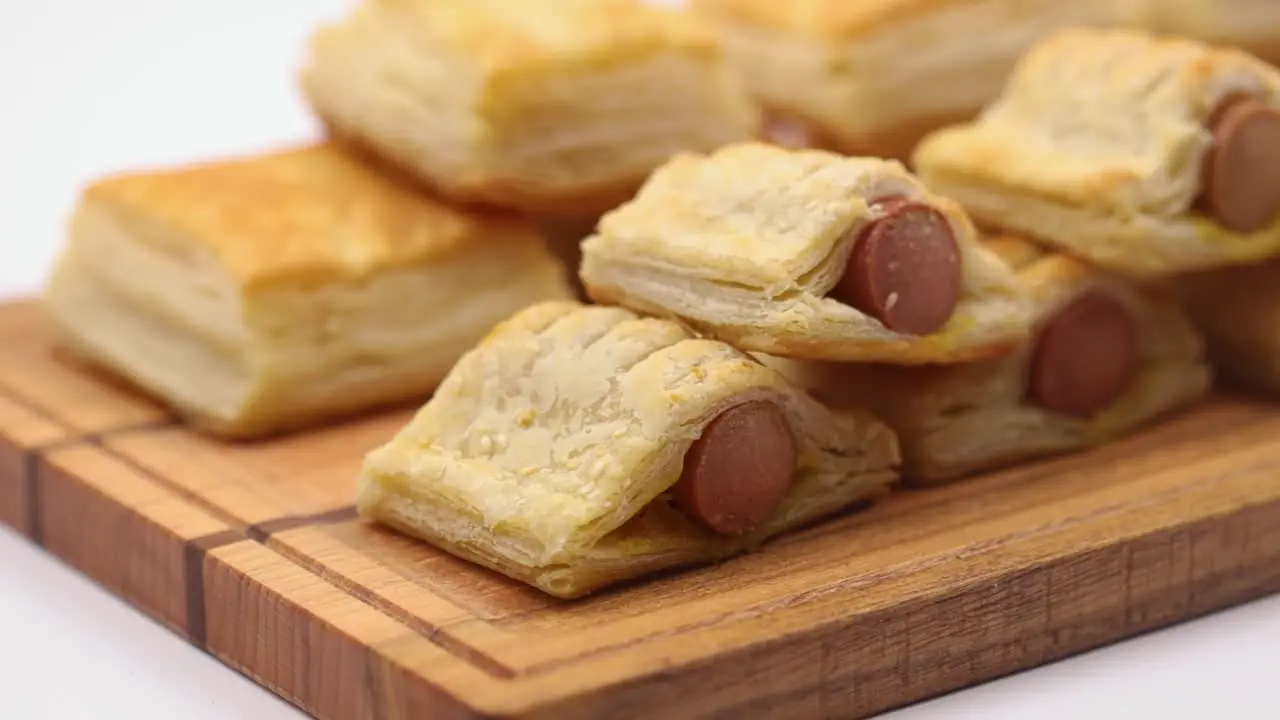 Puff pastry with hot dog served on the wooden board