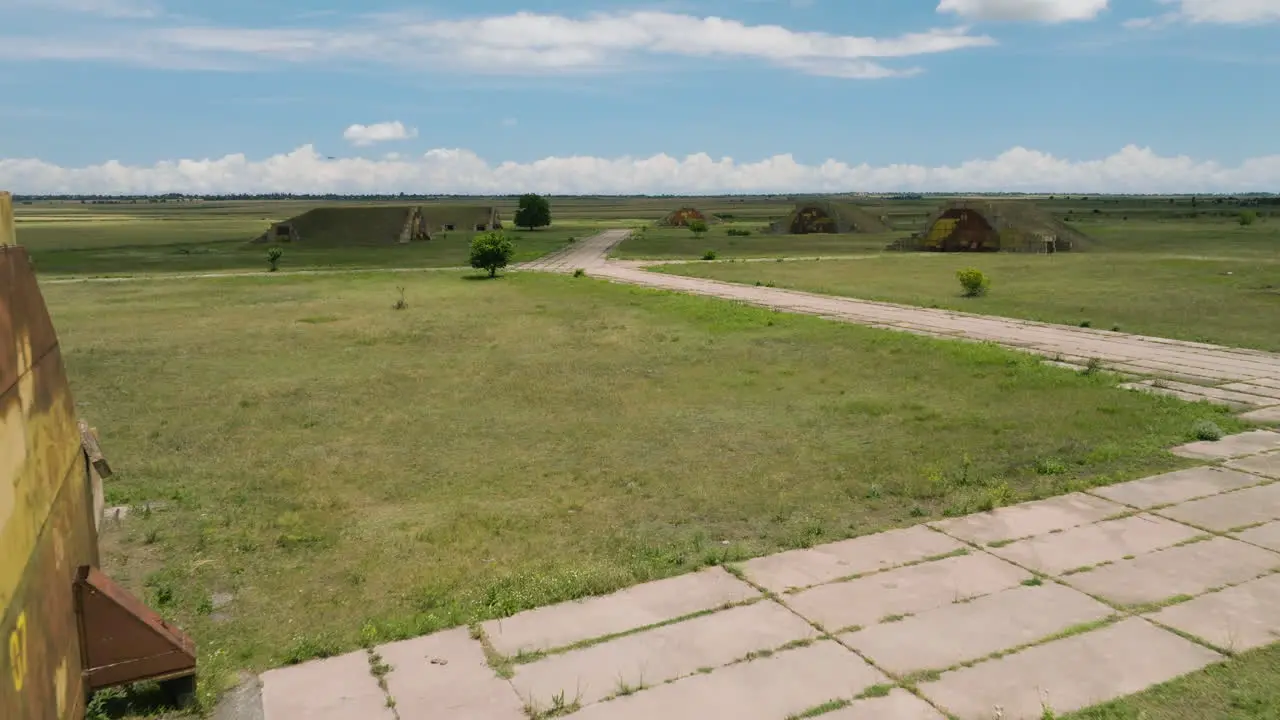 Hangars and runways of abandoned Shiraki military airbase in grassy plain