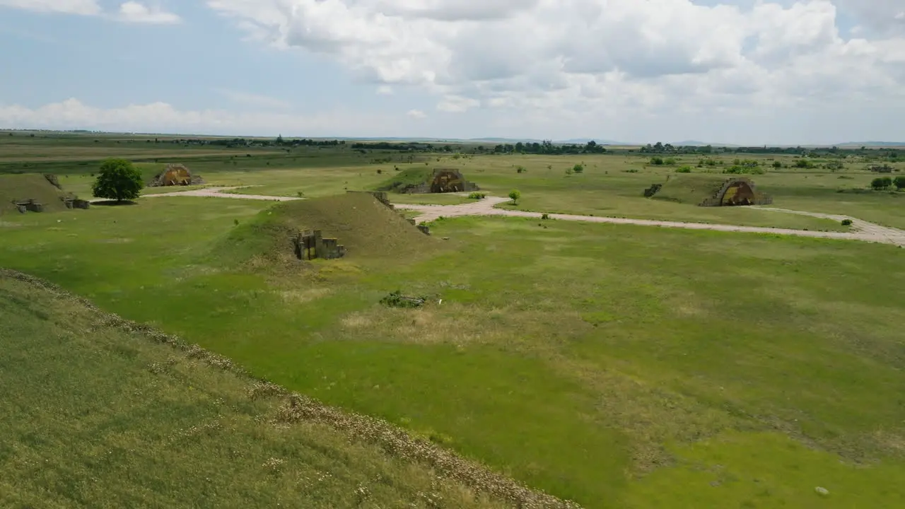 Grass-covered hangars and runways of Shiraki military airbase Georgia