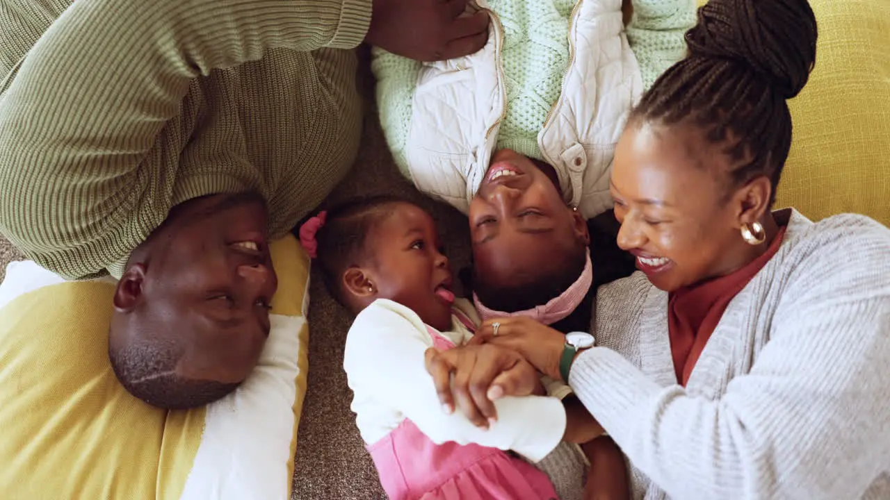 Floor above and black family playing in a living