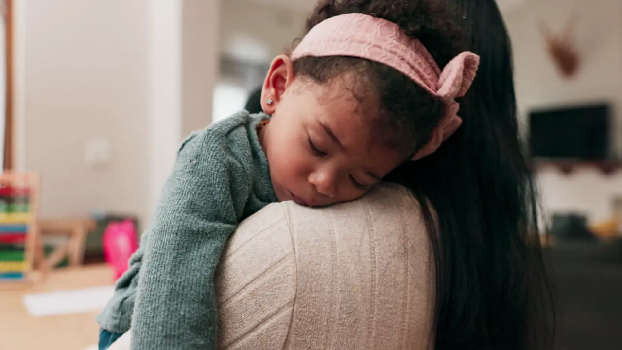 Mom holding sleeping girl and home for care