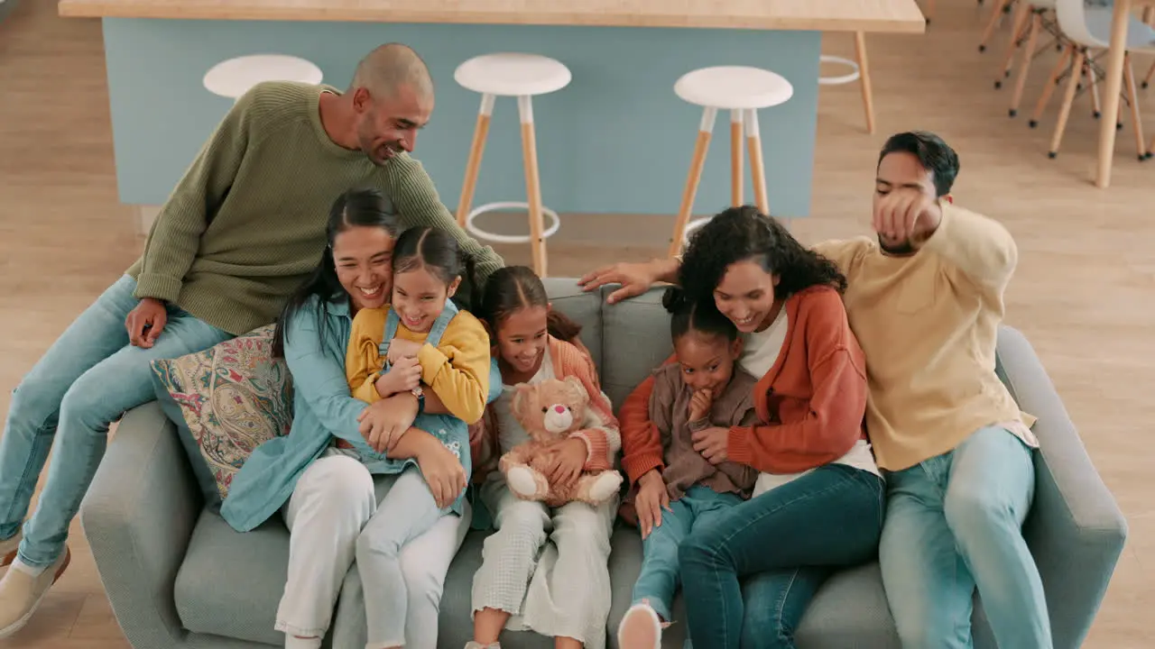 Above hug and big family on the home sofa