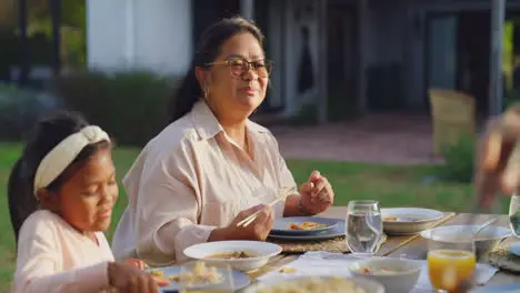 Happy family eating together at a table outside