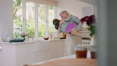 Family kitchen and grandmother lifting girl