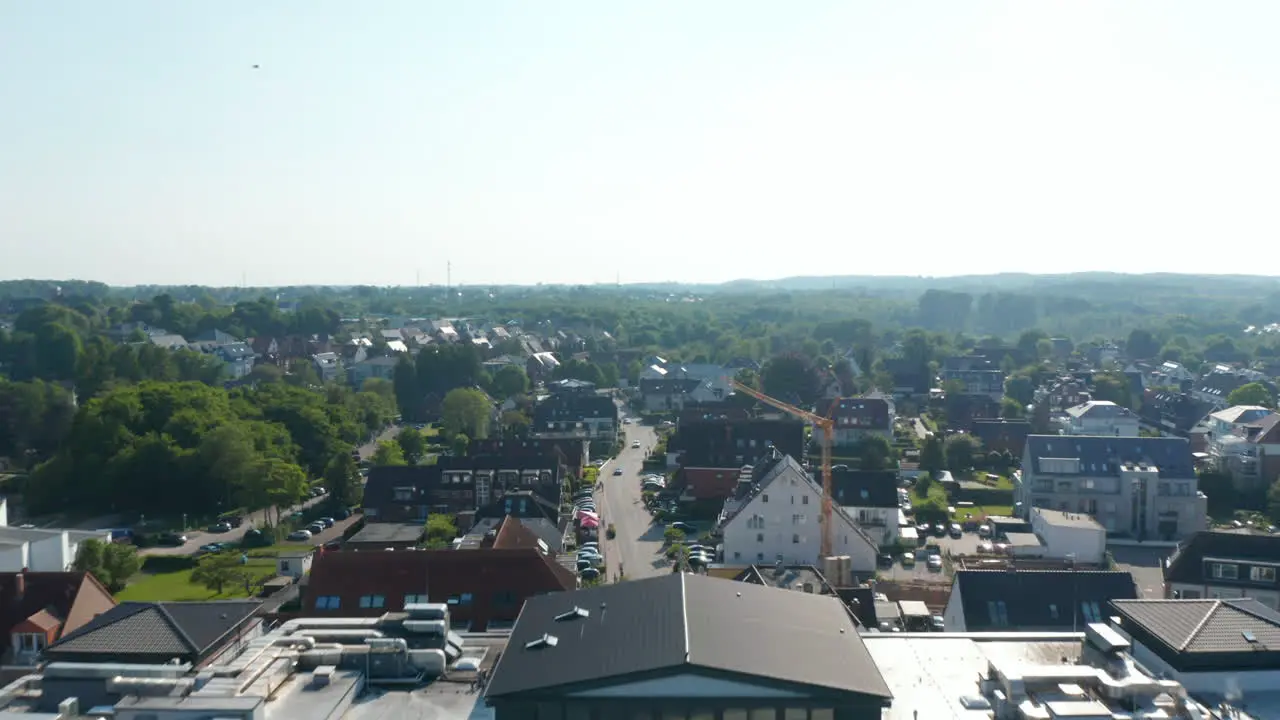 Aerial drone flying forward above resort hotel and houses buildings streets in Scharbeutz Germany day