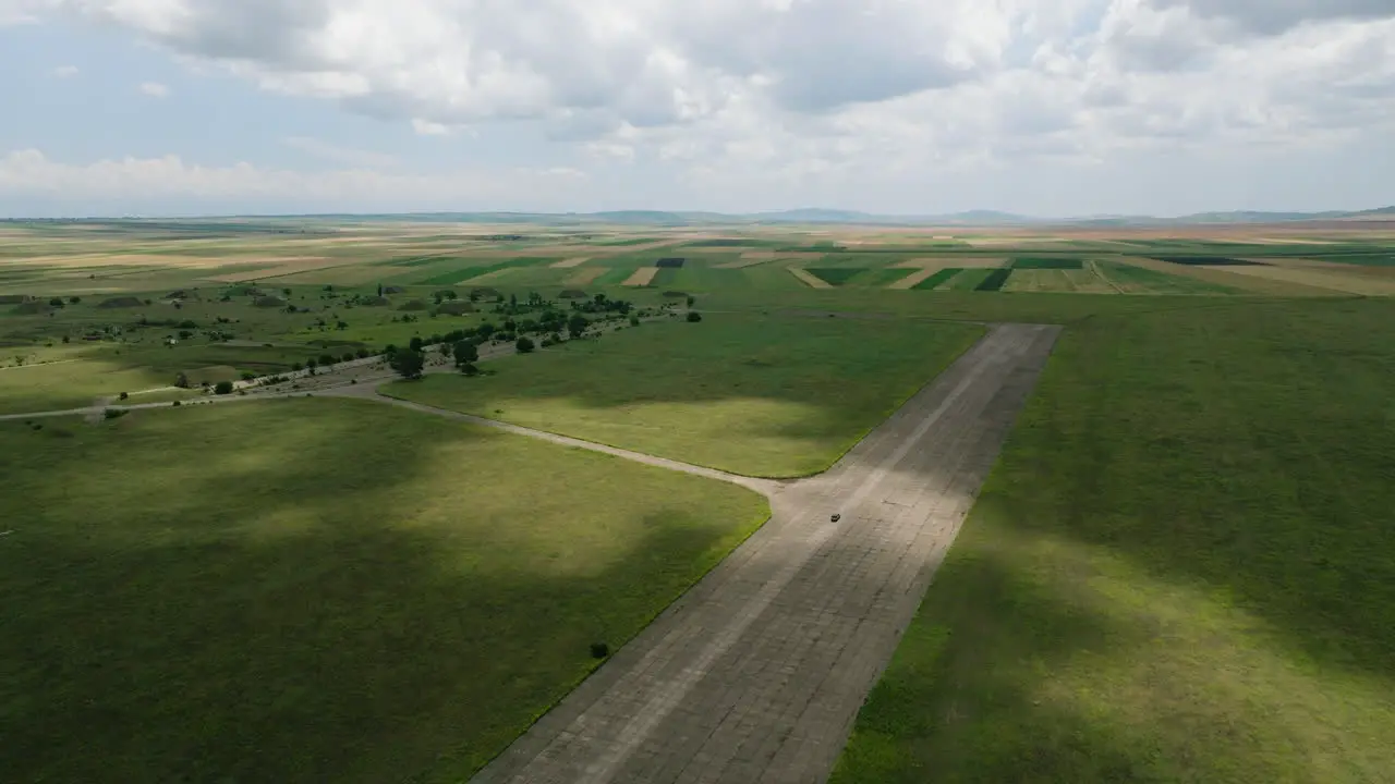 Car driving on wide runway of Shiraki military airfield in Georgia