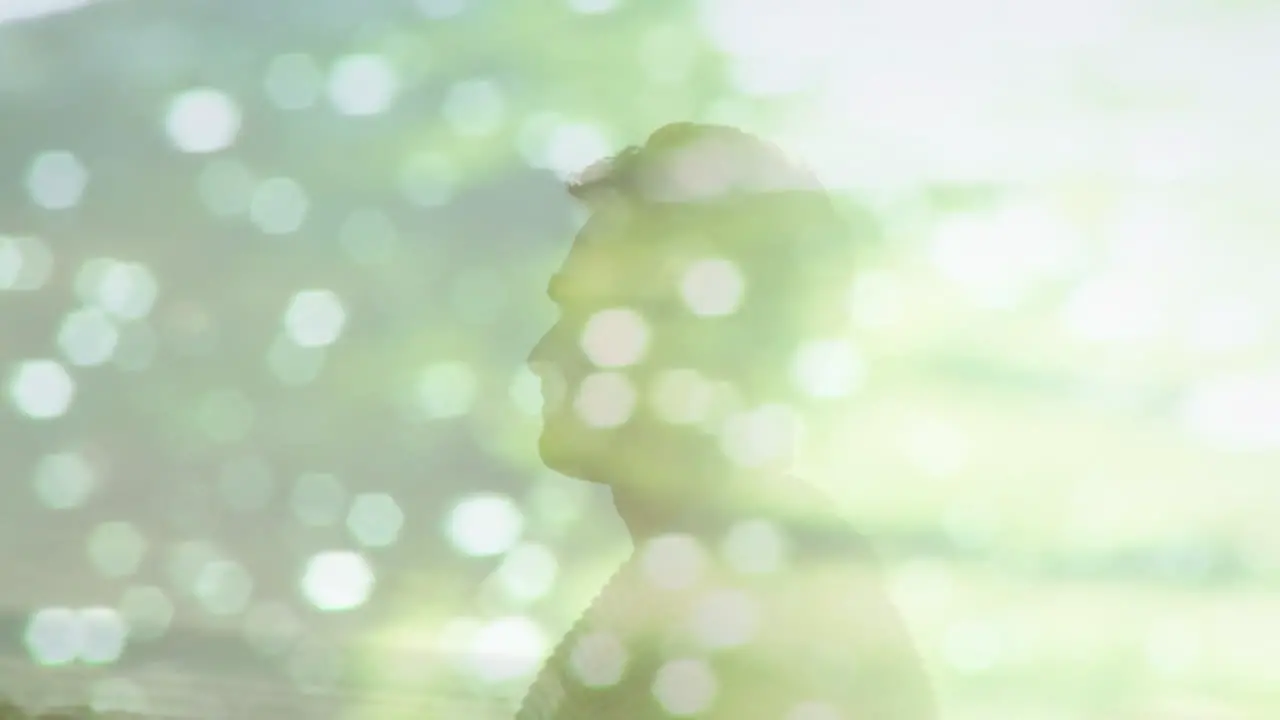 Animation of light reflection over happy caucasian man on beach